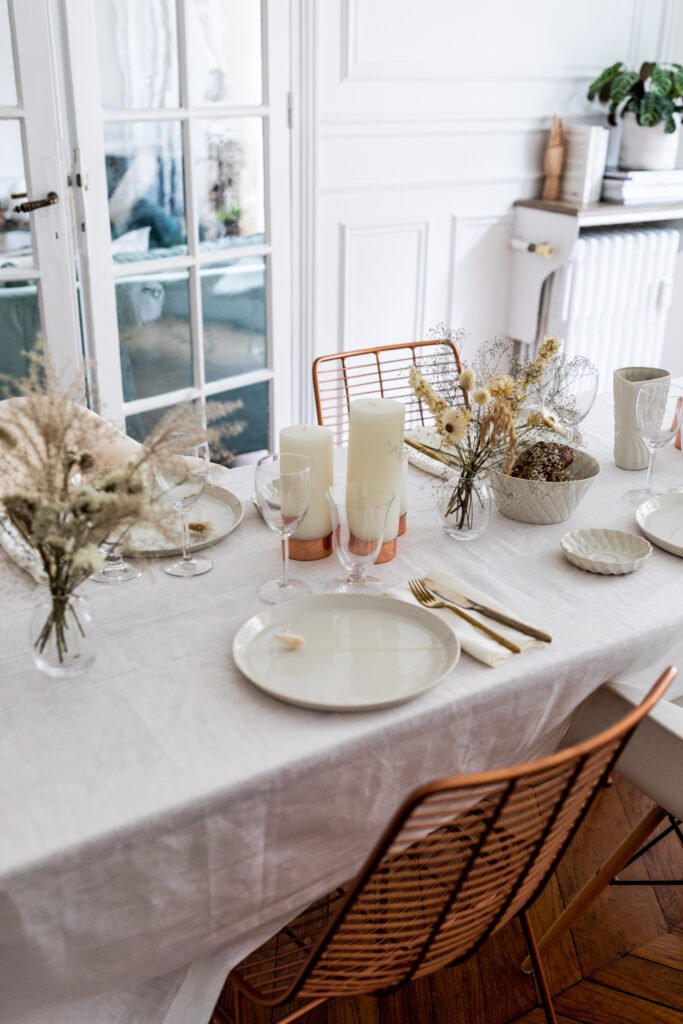 Table de fête blanche et cuivrée avec décoration lumineuse